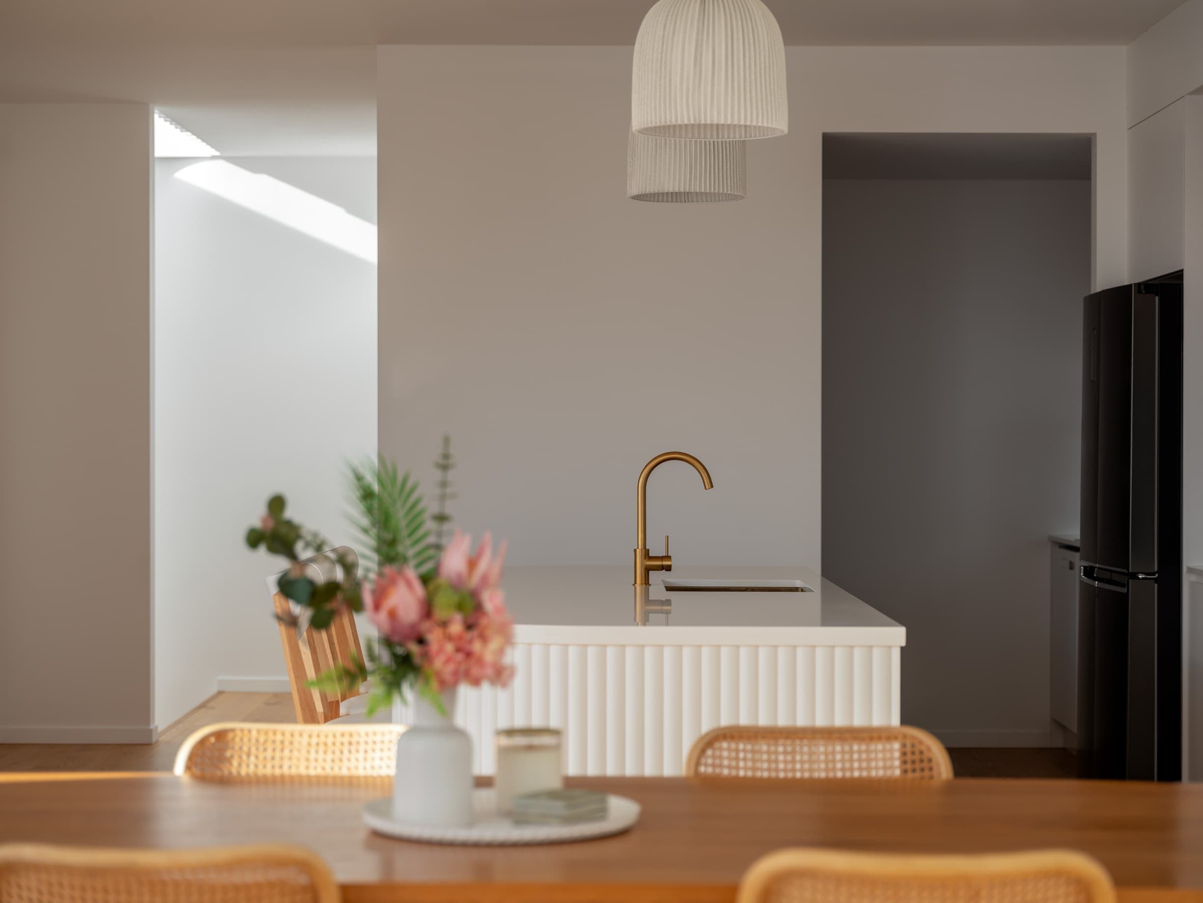 Harding House dining table looking through to the fluted kitchen island