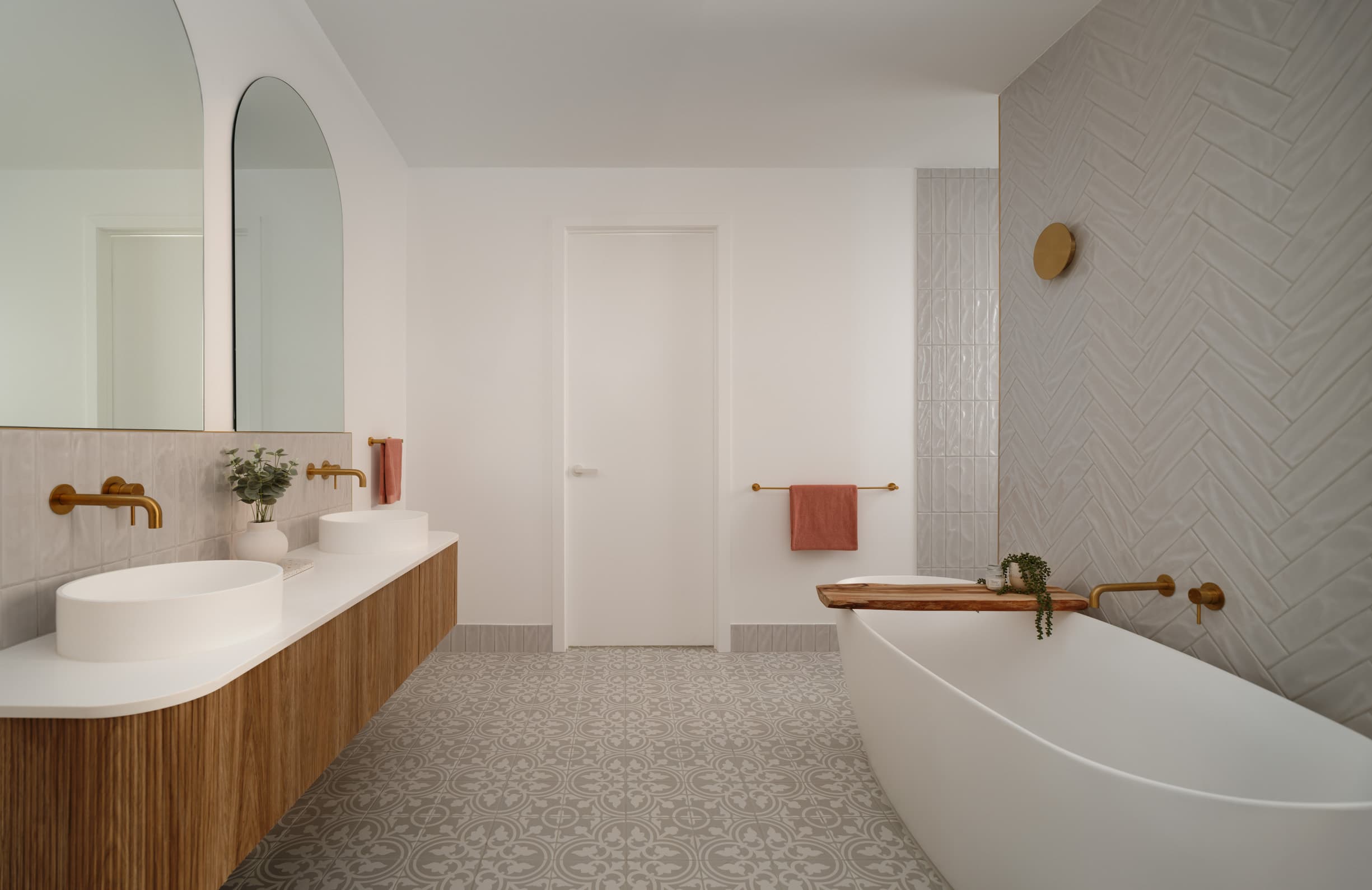 Harding House bathroom with twin basins, arched mirrors and a freestanding bath