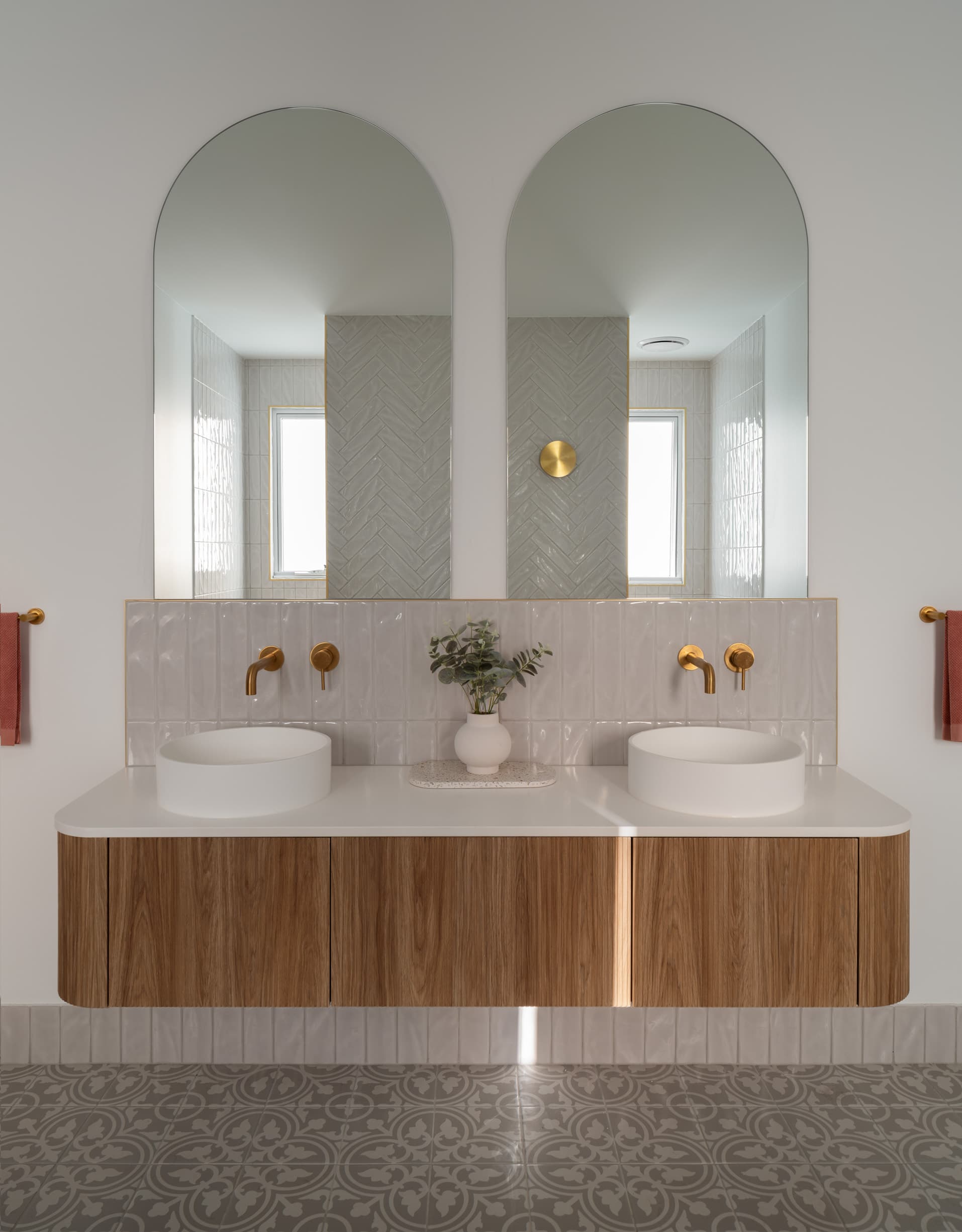 Harding House twin basins on curved oak joinery below two arched mirrors