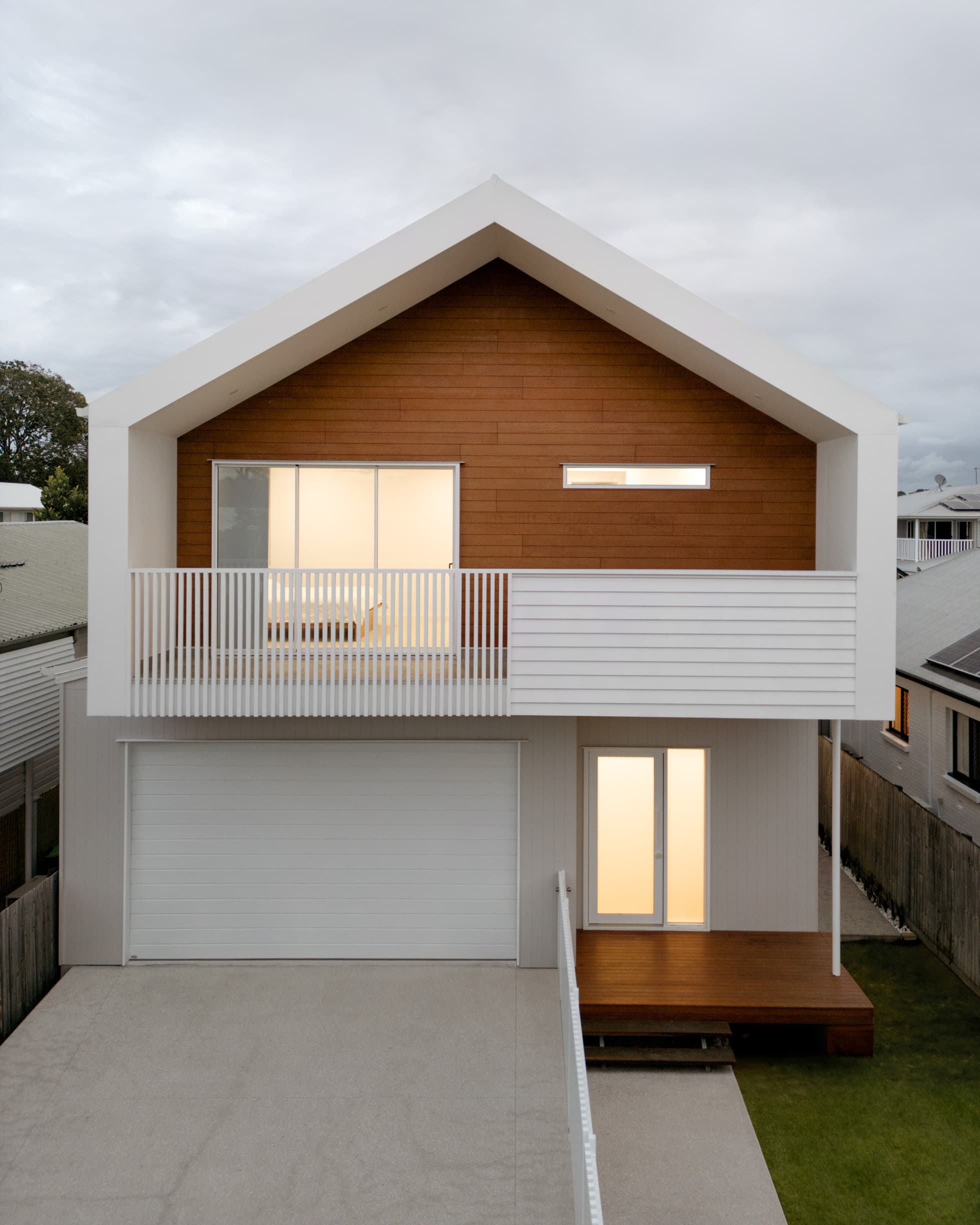 Harding House street elevation at dusk with a timber-clad gable over the garage