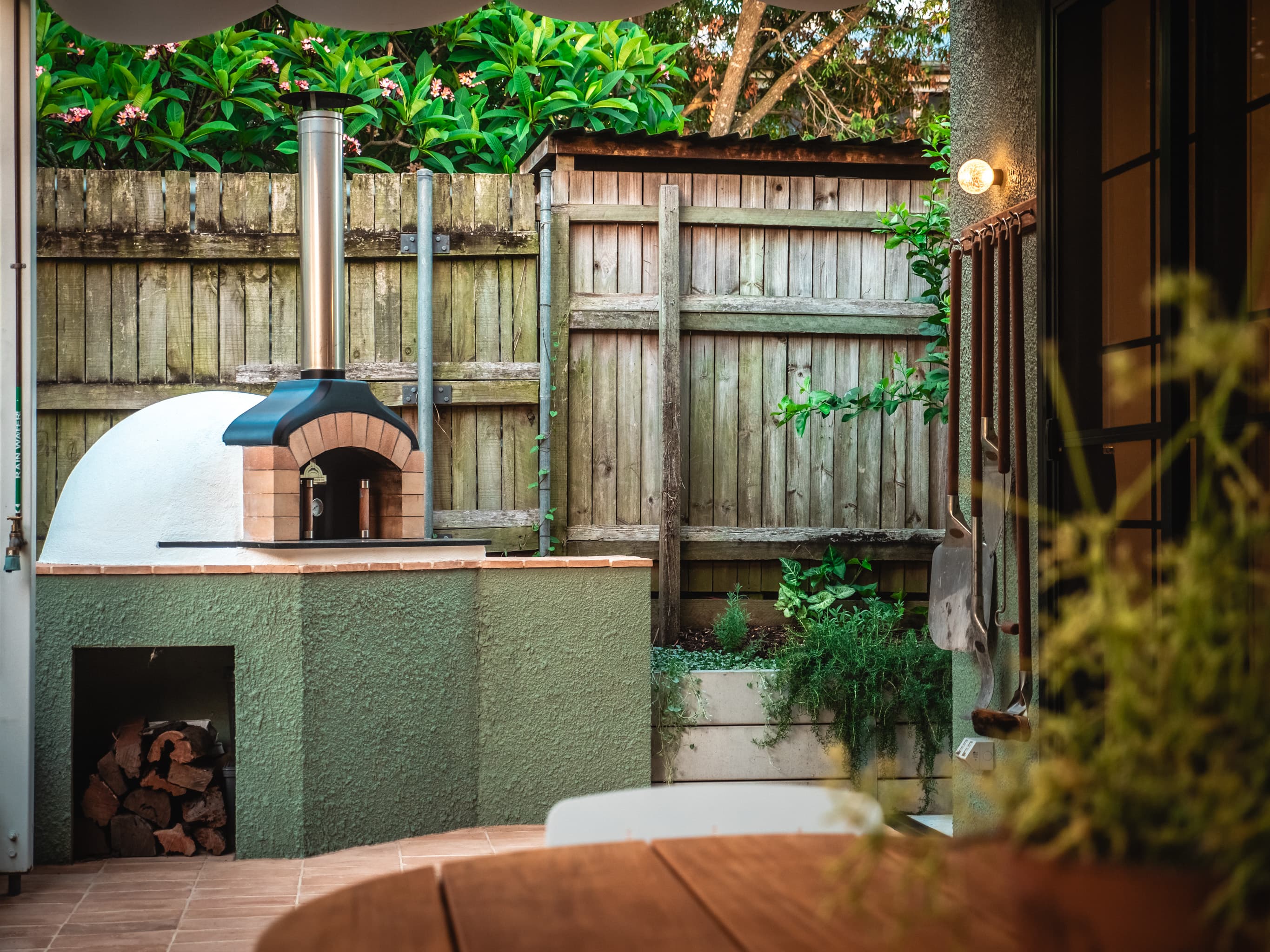 Jacaranda Highside courtyard wood-fired pizza oven with a herb planter