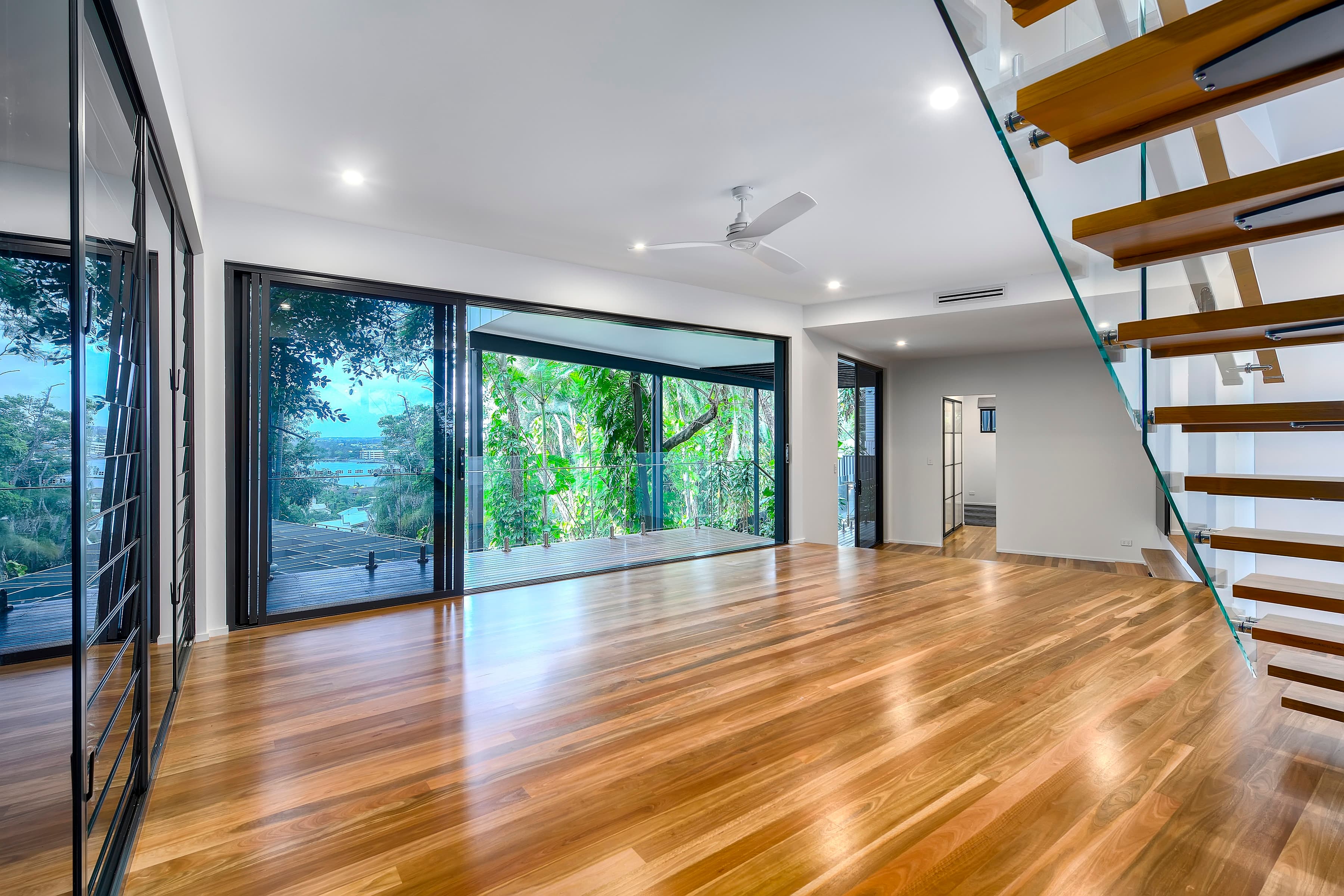 Langside Road upper living opening to the balcony, treetops and water beyond