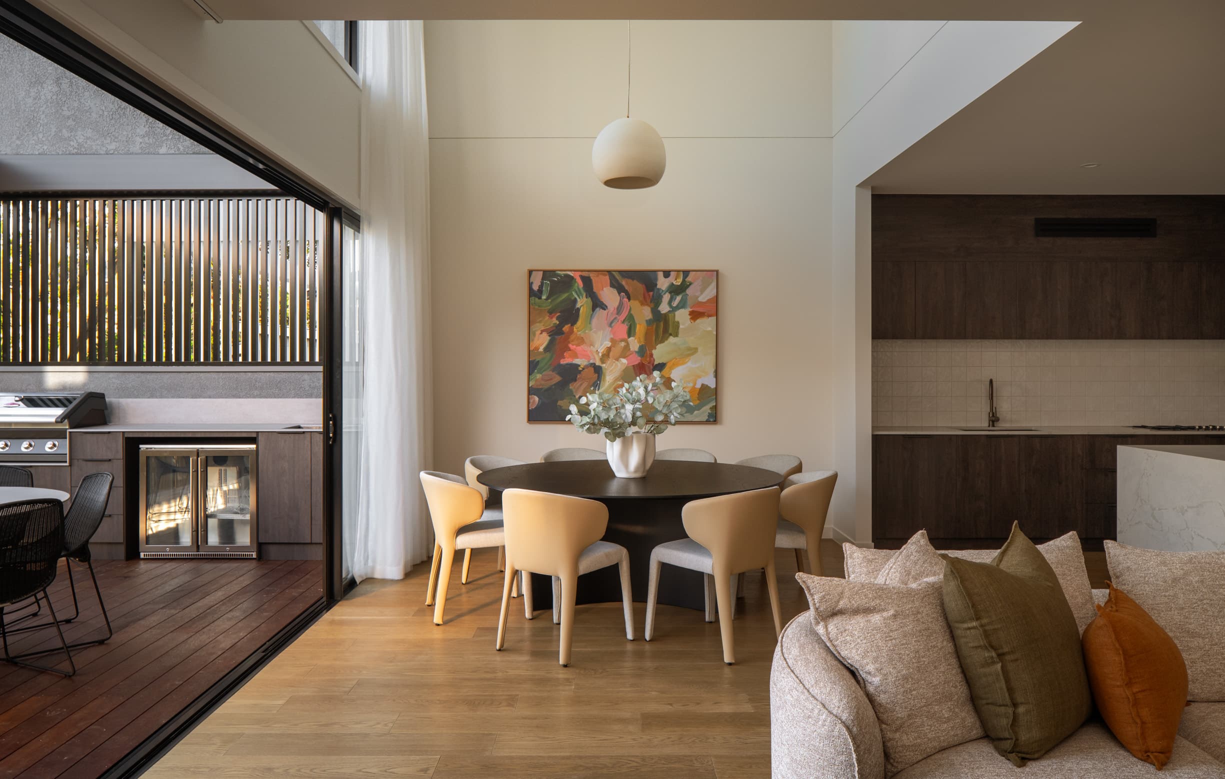 Lindsay House dining table beside sliding doors opening to the covered deck