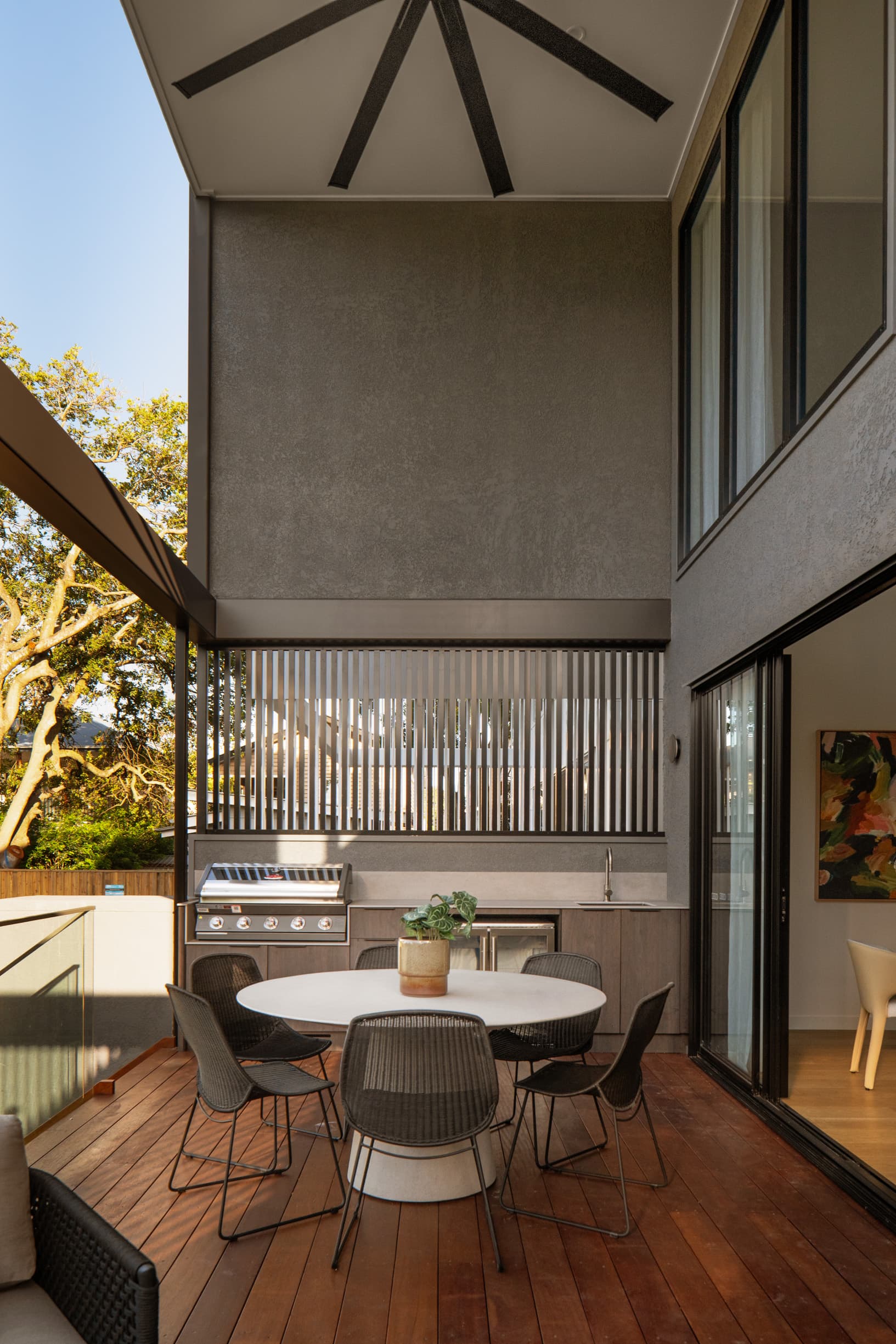 Lindsay House covered deck with an outdoor kitchen and screened balustrade