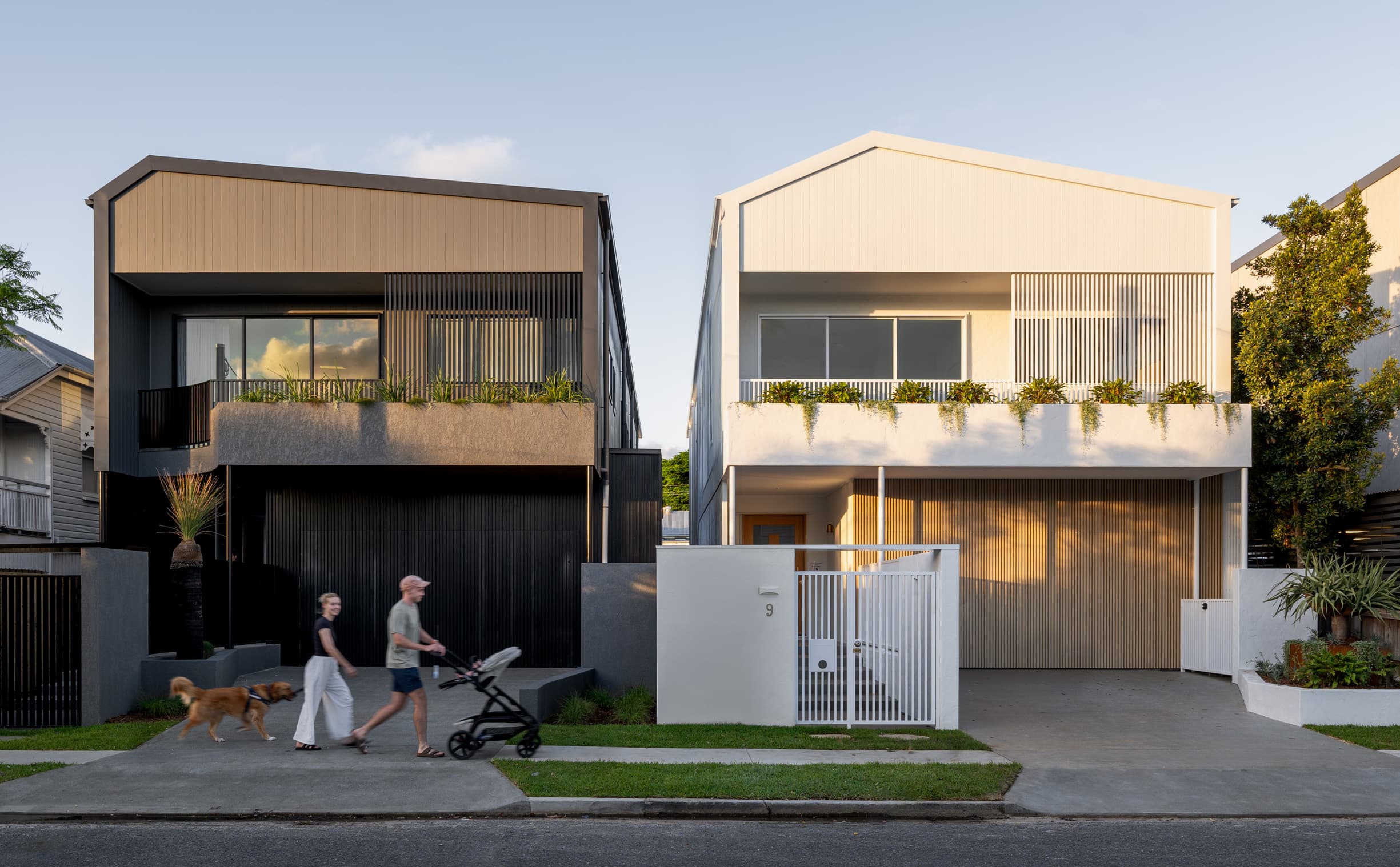 Lindsay House and its adjoining pair seen from the street at dusk, with a family walking past on the footpath