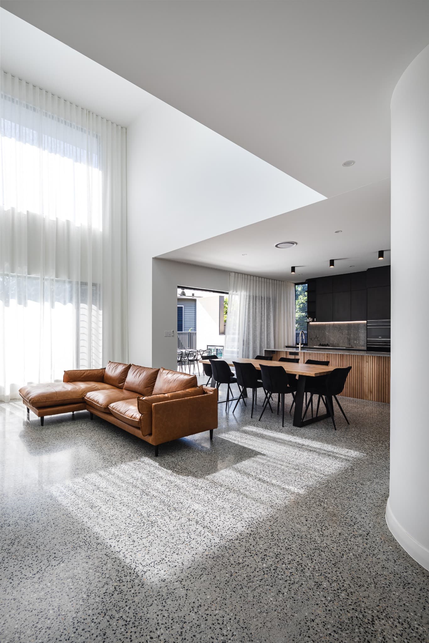 Melville Terrace double-height living room with a polished concrete floor and leather sofa