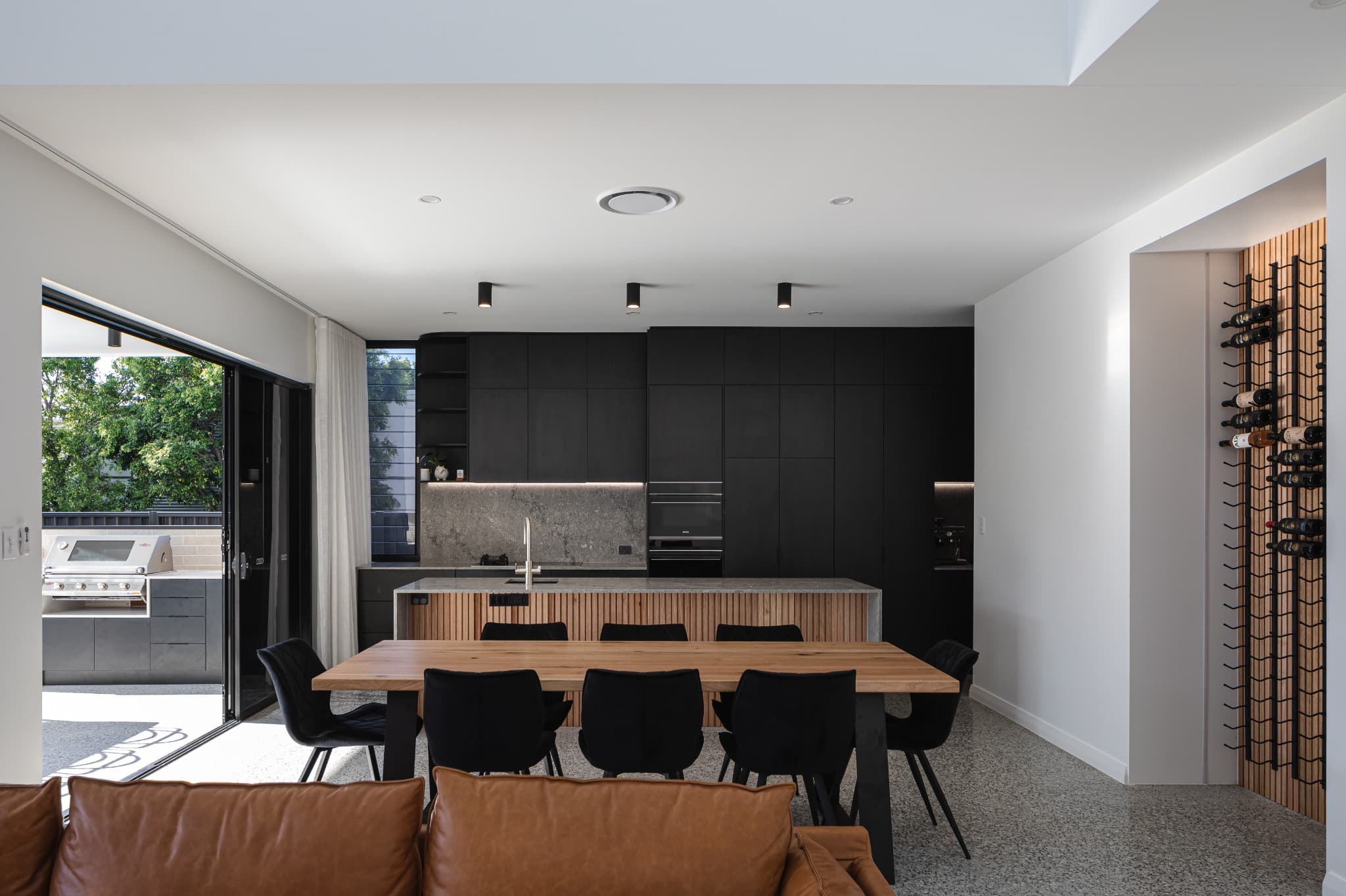 Melville Terrace kitchen and dining with black joinery and a timber-battened island