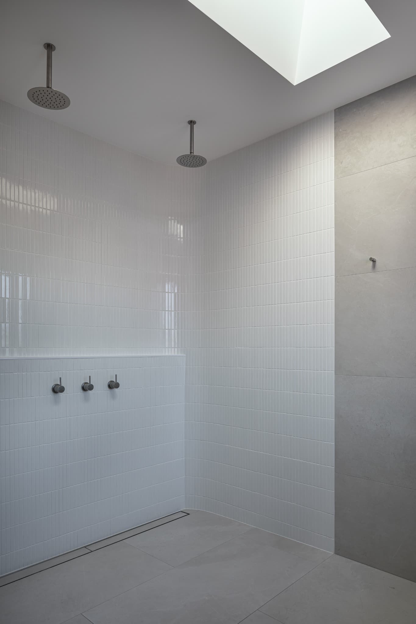 Melville Terrace twin-shower wet room in white finger tiles under a skylight