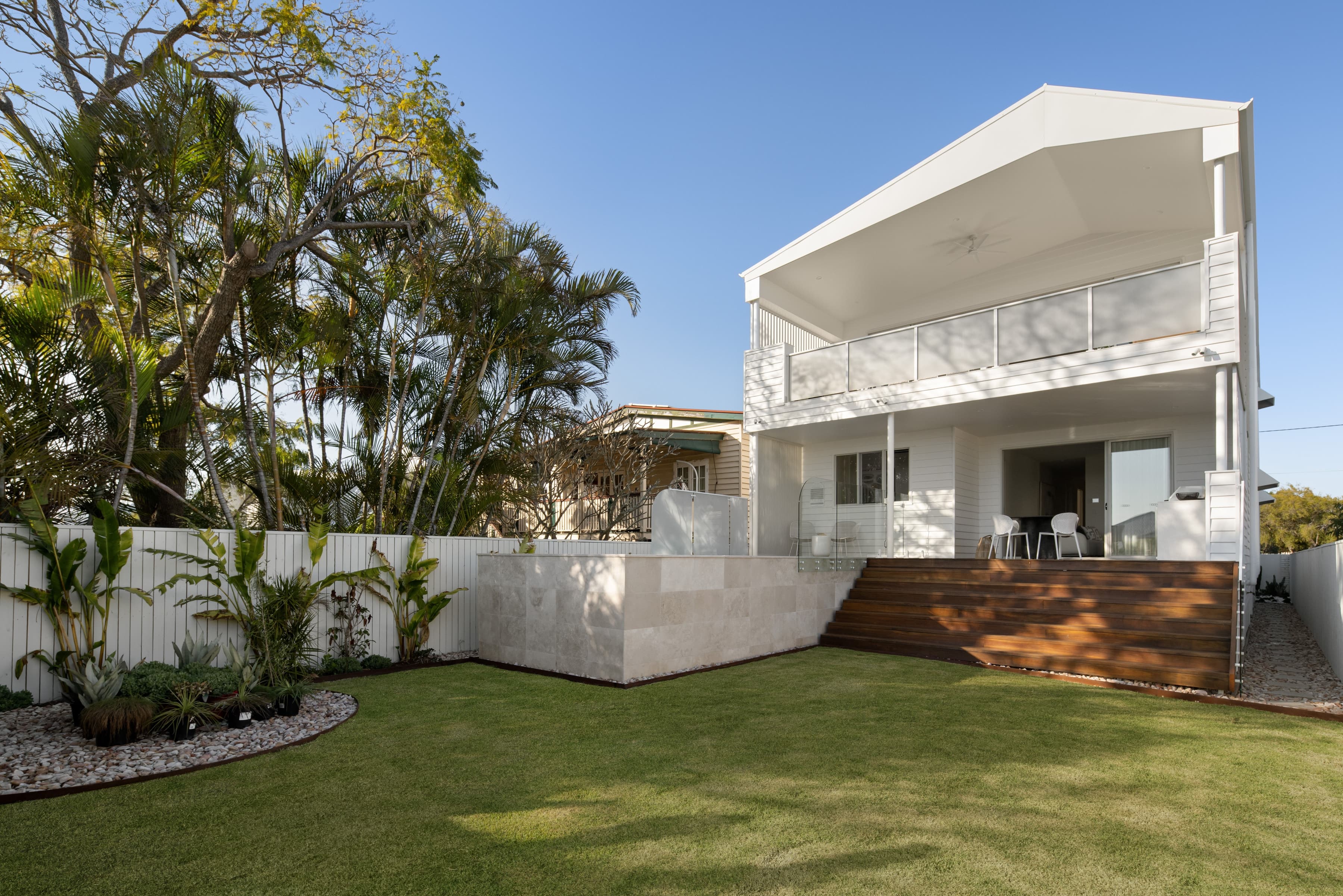 Mesa rear garden and lawn with the two-storey home and upper balcony beyond
