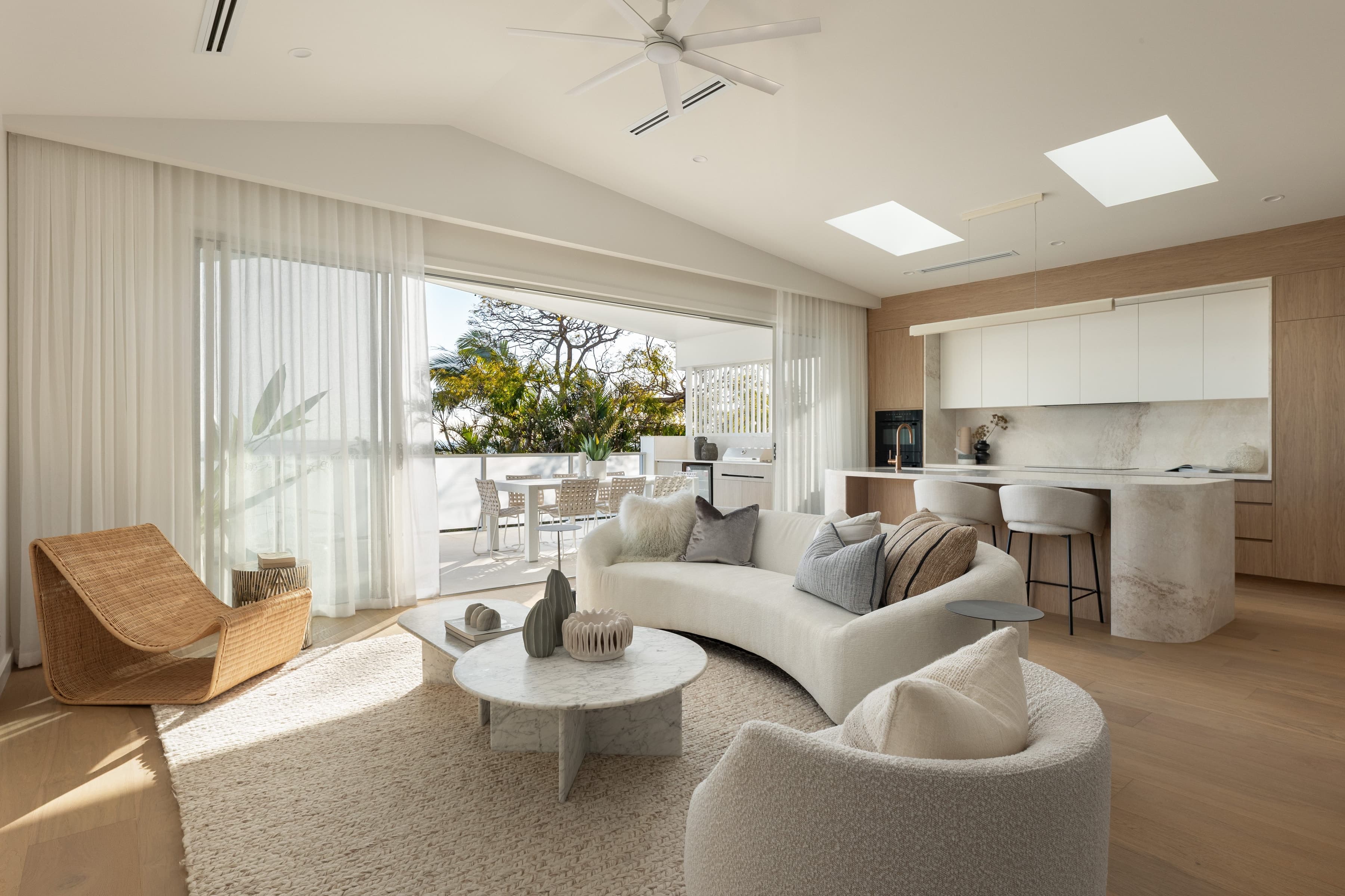 Mesa living room under a raked ceiling, opening to the balcony with the kitchen beyond