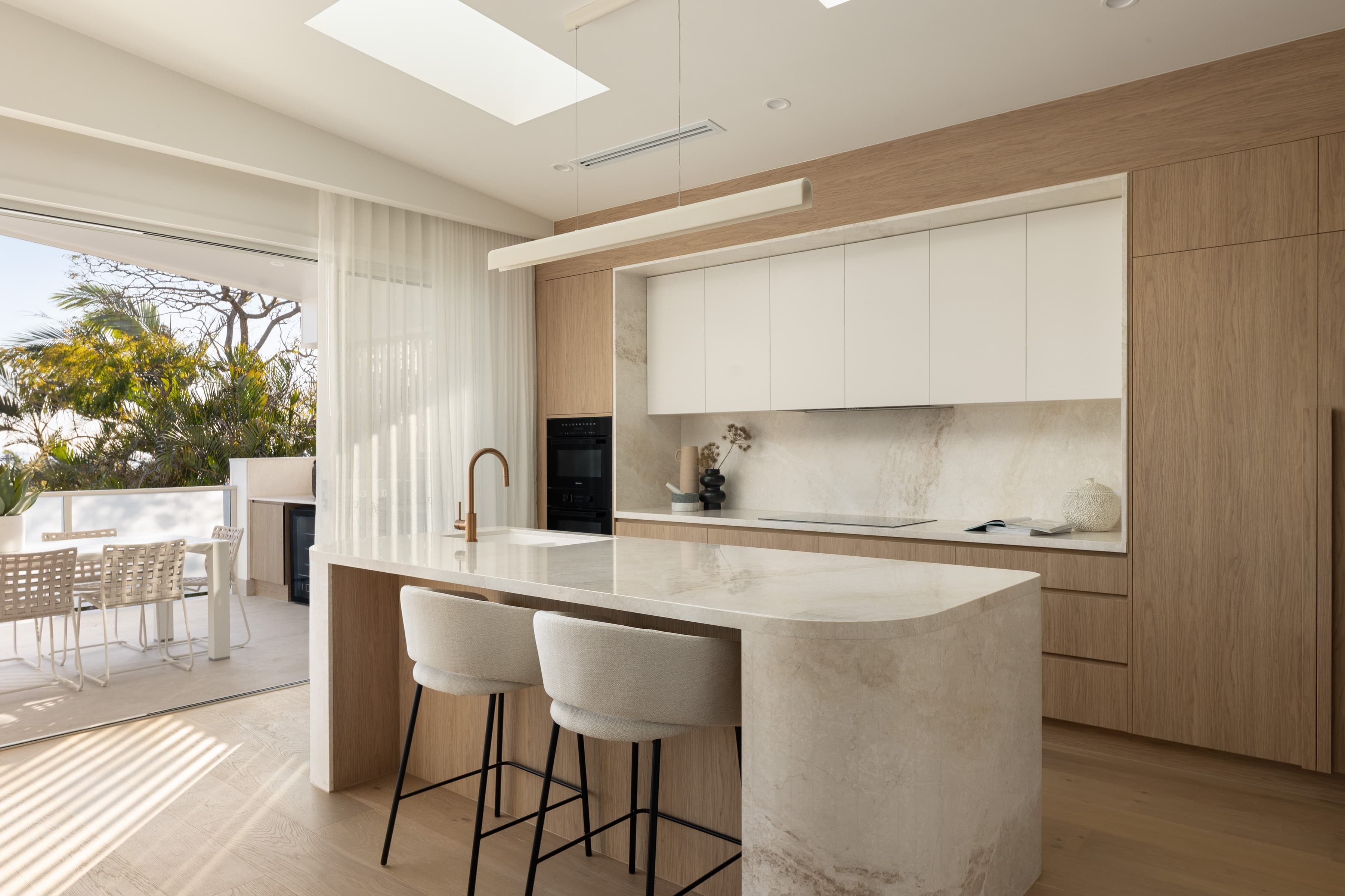 Mesa kitchen with a stone island, oak joinery and sliding doors to the balcony