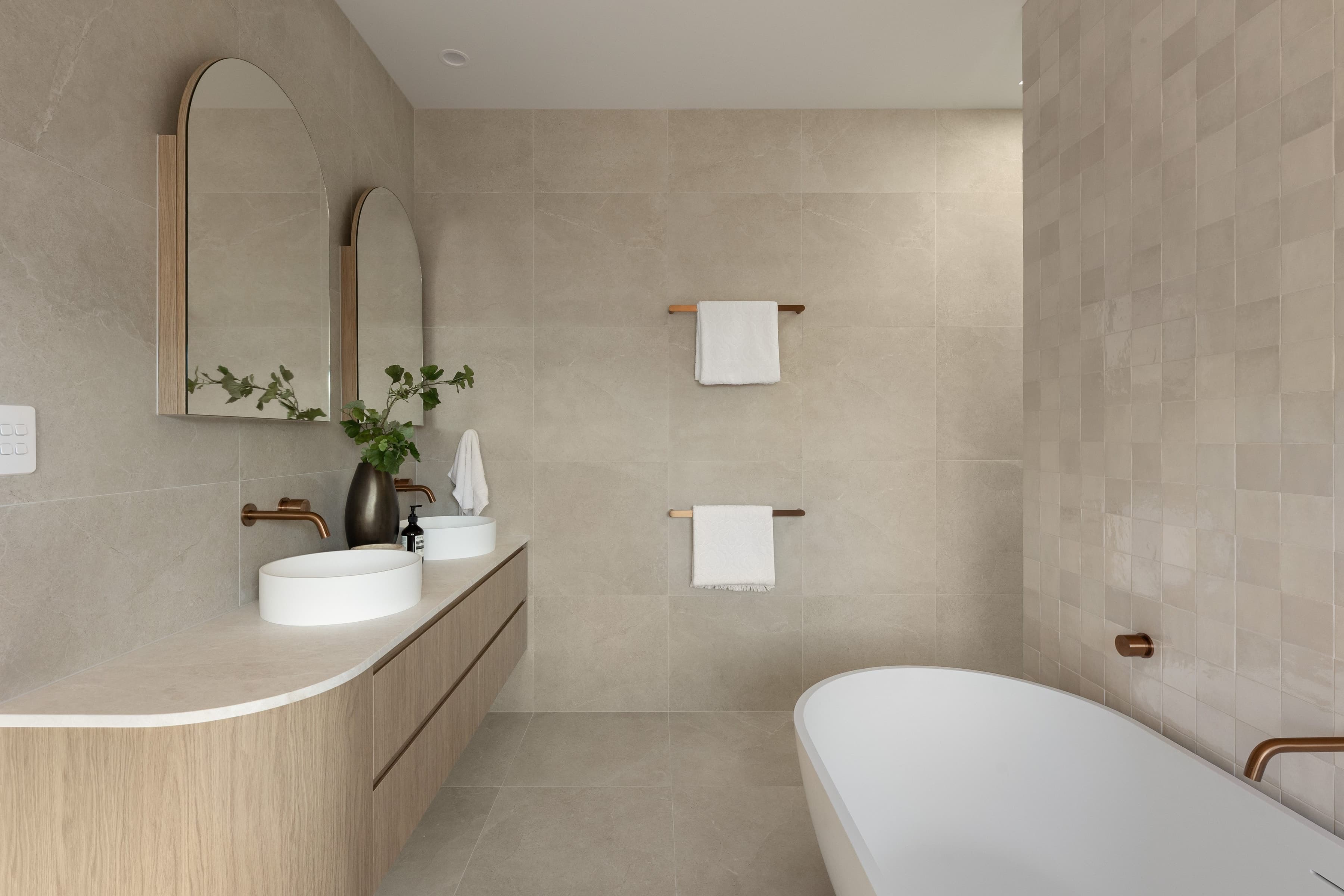Mesa ensuite with twin basins, arched mirrors and a freestanding bath