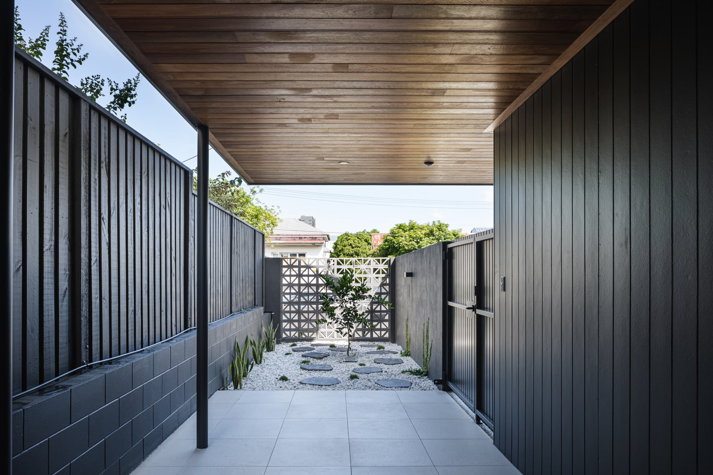 Z House side courtyard with a breeze-block screen and stepping stones